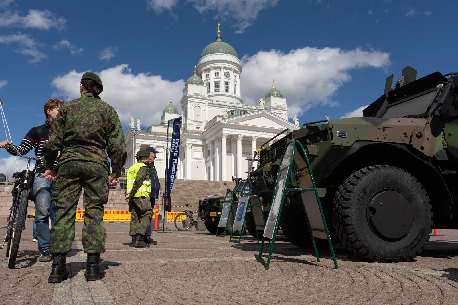 Kuva on Tuomiokirkon edustalta, siinä näkyy kalustoesittelyssä erinäisiä ajoneuvoja mm. puolustusvoimilta. Kuvassa on myös univormuissa olevia armeijan palveluksessa olevia henkilöitä jotka keskustelevat yksityishenkilöiden kanssa. 