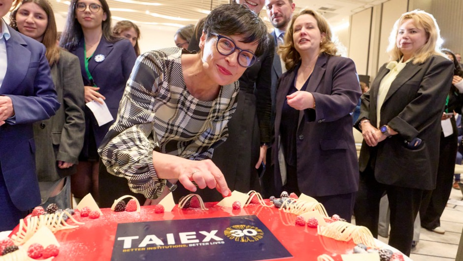 Laajentumiskomissaari Marta Kos TAIEX-ohjelman 30-vuotisjuhlakakun ääressä.