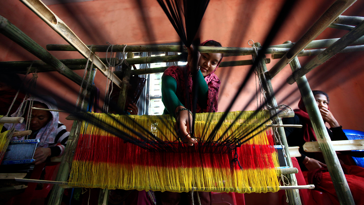 Nepalese woman studying weaving.