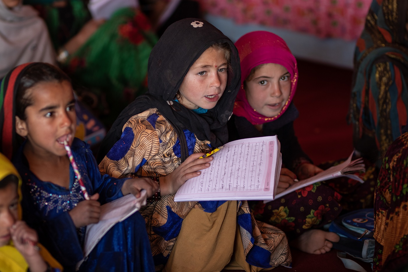 Kolme afganistanilaista tyttöä opiskelemassa.