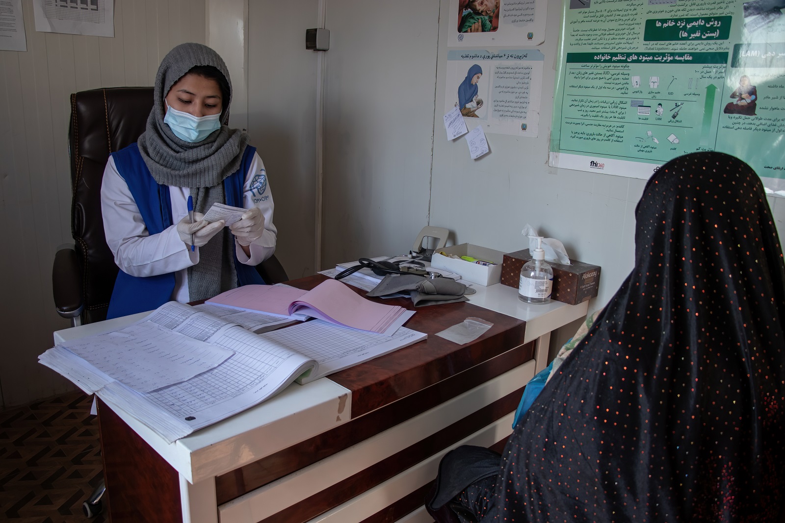 Afganistanilainen nainen istuu lääkärin vastaanotolla naistentauti- ja synnytysosastolla.