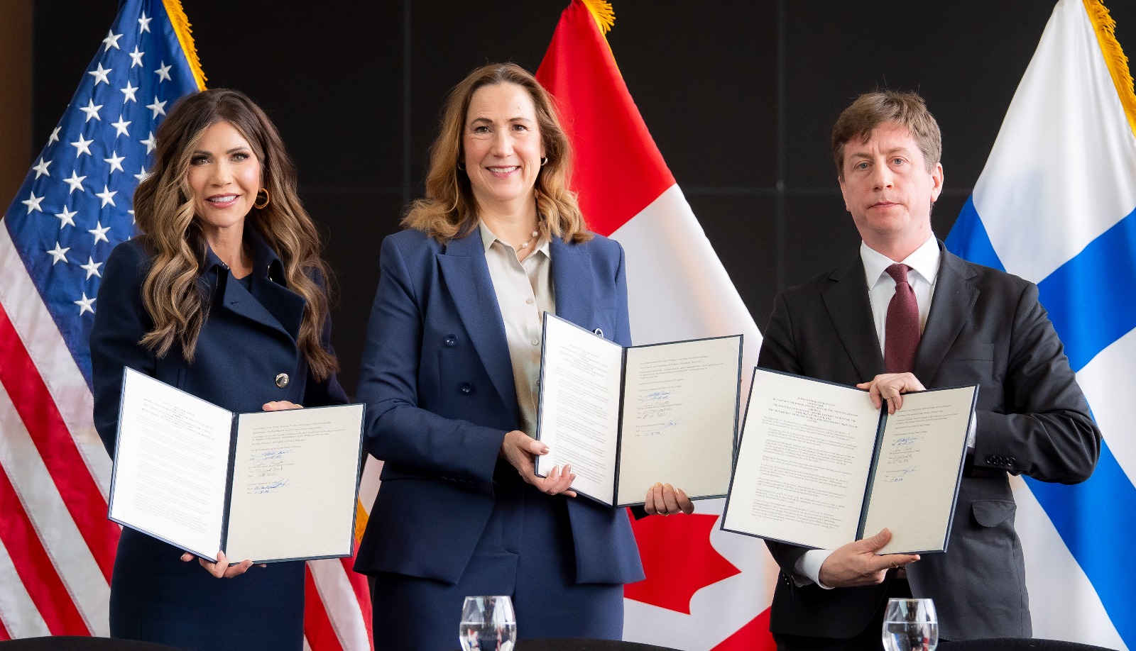Kristi Noem, Kirsten Hillman ja Sakari Puisto pitelevät julkilausumaa käsissään