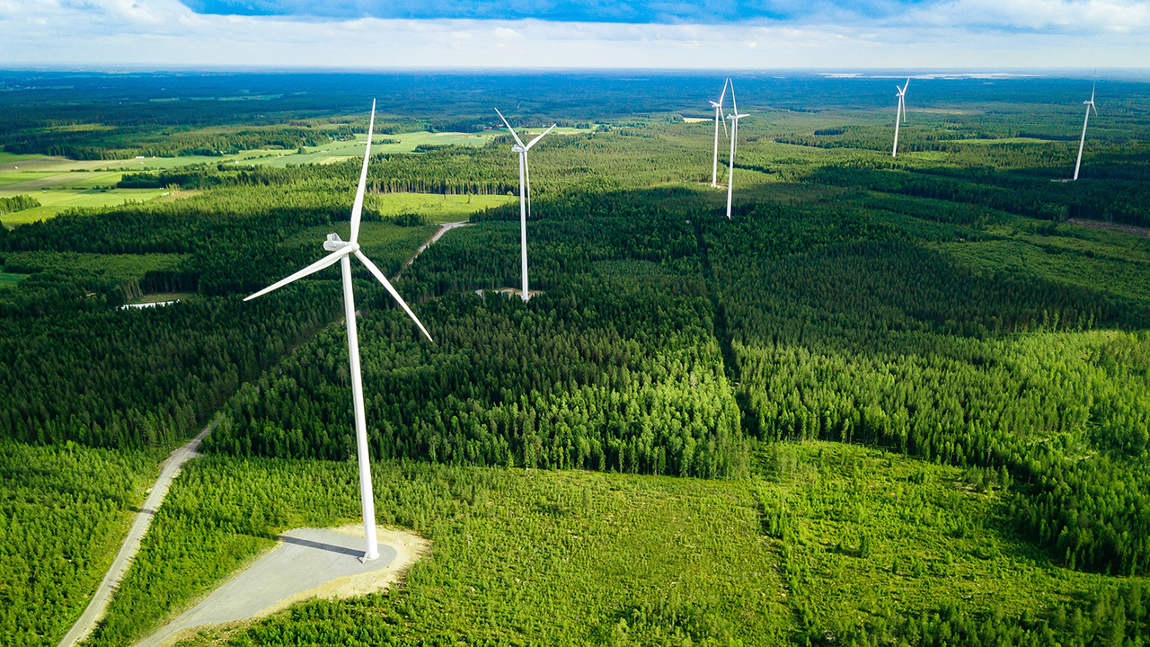 Aerial view of windmills in summer forest in Finland.
