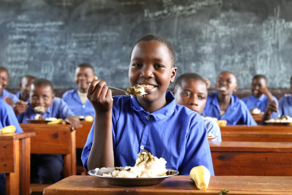Ruandalainen Niyogisubizo Shalifu nauttii kouluruoasta Ngoman alueella, jossa WFP tukee 32:ta koulua. Kuva: Maailman ruokaohjelma WFP.