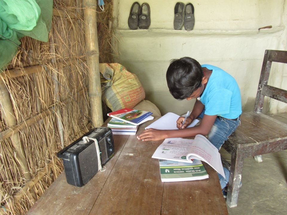 En pojke studerar vid bordet och en radio står på bordet