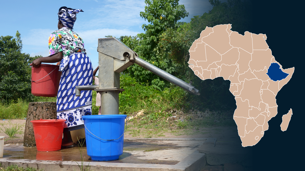 En etiopisk kvinna lyfter upp en hink med vatten vid en brunn.