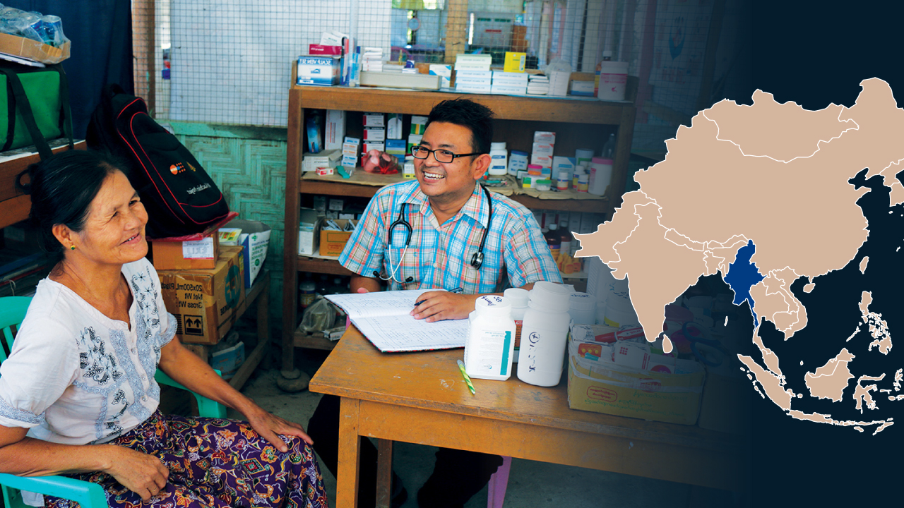 En flyktingkvinna sitter vid samma bord med en läkare på en mobil klinik. På bilden finns också en karta över Asien markerad med Myanmar.