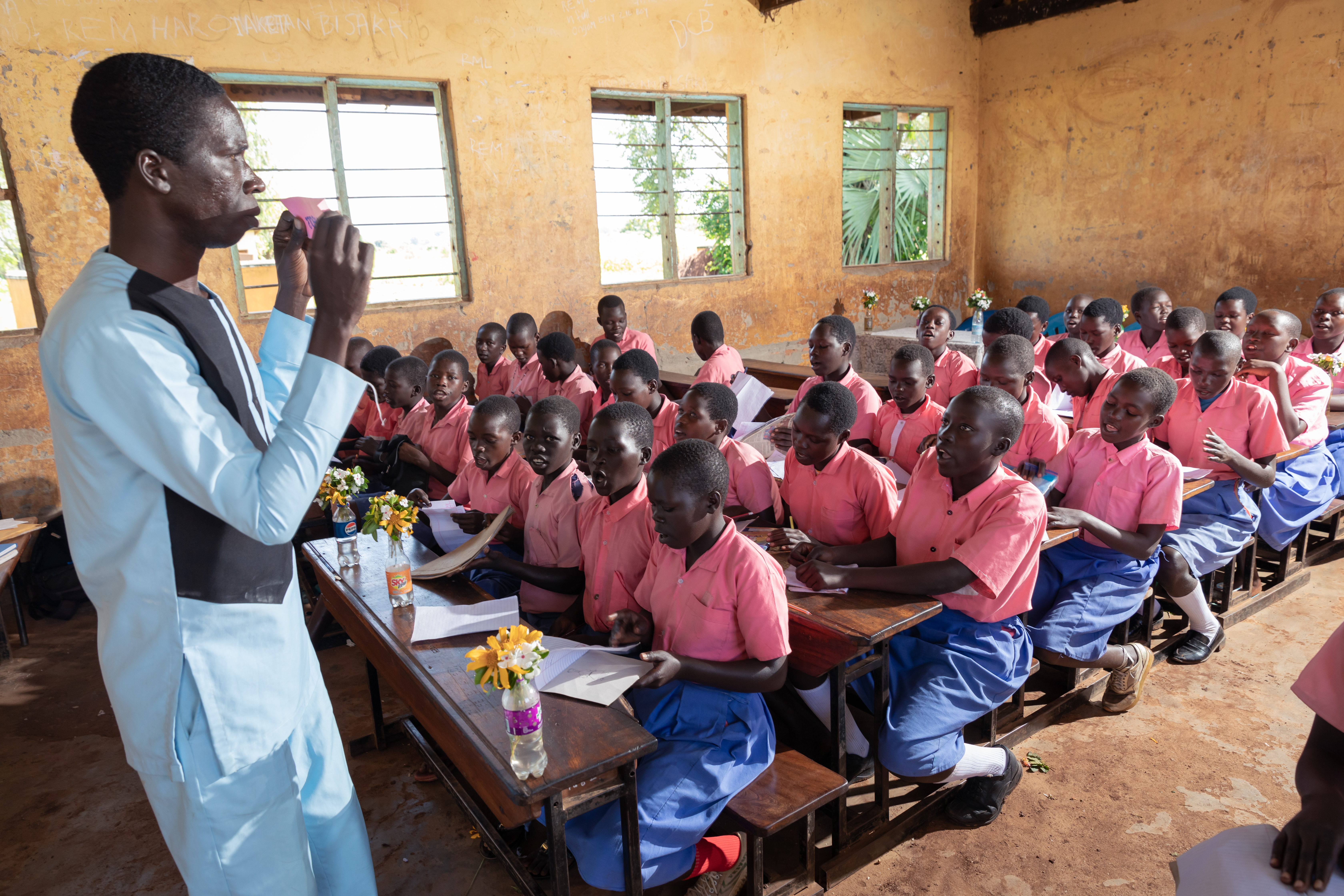 Opettaja opettaa oppilaita ugandalaisessa koululuokassa. 