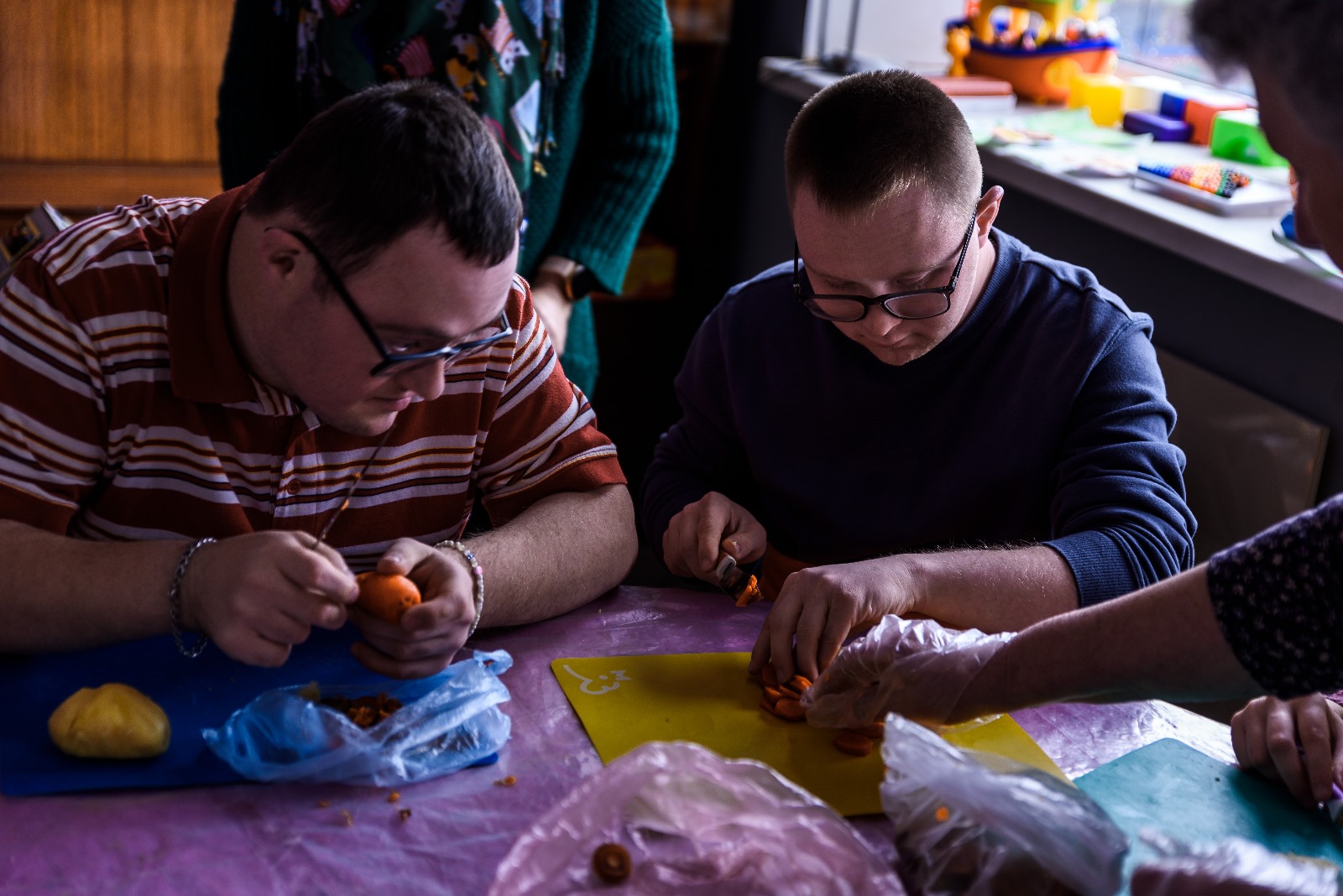 Kaksi ukrainalaista kehitysvammaista nuorta askartelee pöydän ääressä.
