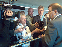 Minister Väyrynen omgiven av medier utanför mötesplatsen.
