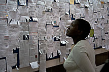 Nainen katselee työpaikkailmoituksia nairobilaisen ostoskeskuksen ilmoitustaululta. Kuva: Milma Kettunen.