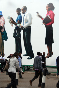 Nairobilaiset ohittavat ison mainosplakaatin. Kuva: Milma Kettunen