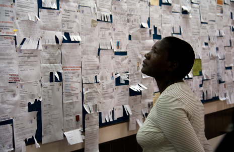 Nainen katselee työpaikkailmoituksia nairobilaisen ostoskeskuksen ilmoitustaululta. Kuva: Milma Kettunen 