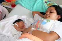 Nicaragualainen äiti vastasyntyneine lapsineen sairaalavuoteella.