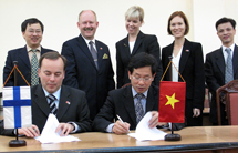 Chefsförhandlarna Pekka Puustinen och Ho Quang Minh undertecknar dokumentet. Bild: Marja-Leena Kultanen